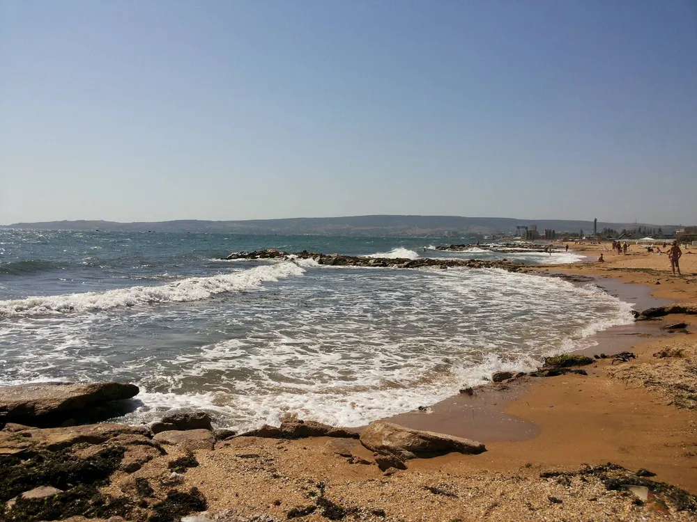 Морской прибой и песчаный берег Золотого пляжа в Крыму
