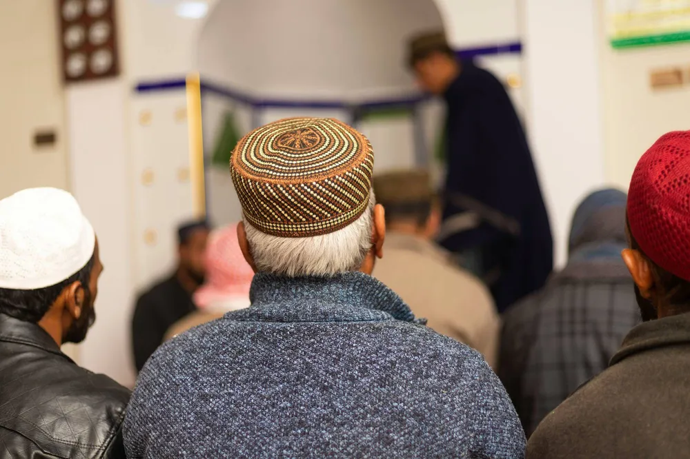 Мужчины в тюбетейках в мечети