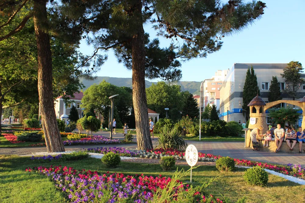 Люди гуляют на зеленой набережной в Геленджике