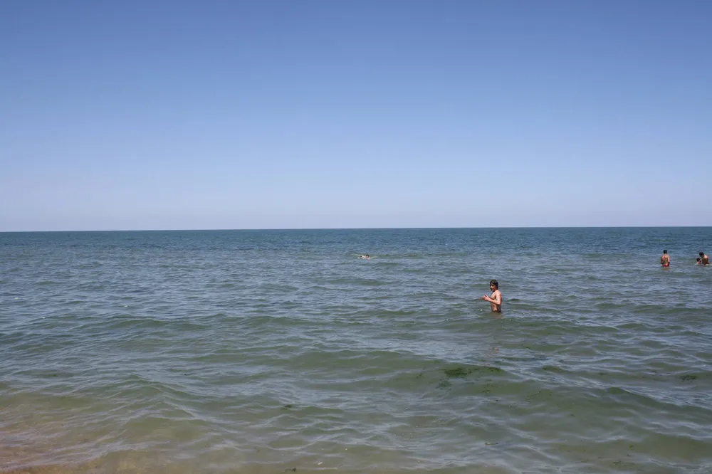 Люди купаются в Каспийском море в Дербенте