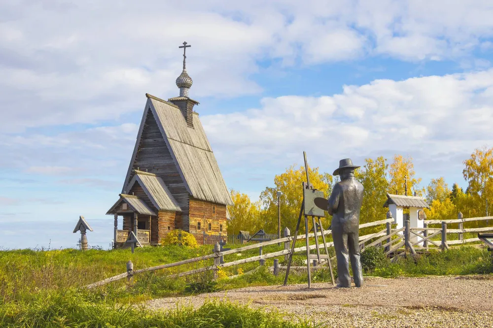 Памятник Левитану у старинной деревянной церкви на Горе Левитана в Плесе