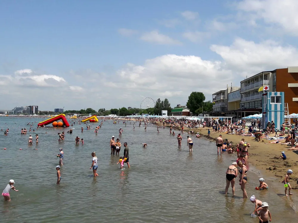 Люди отдыхают на песчаном пляже в Анапе на Черном море