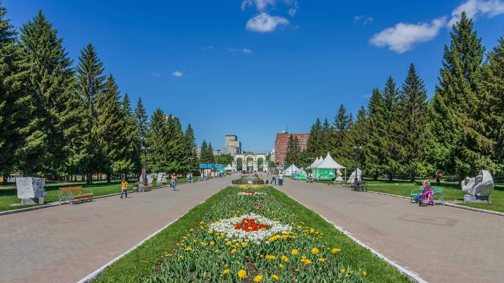 Центральная аллея с клумбами и елями в Парке Маяковского в Екатеринбурге