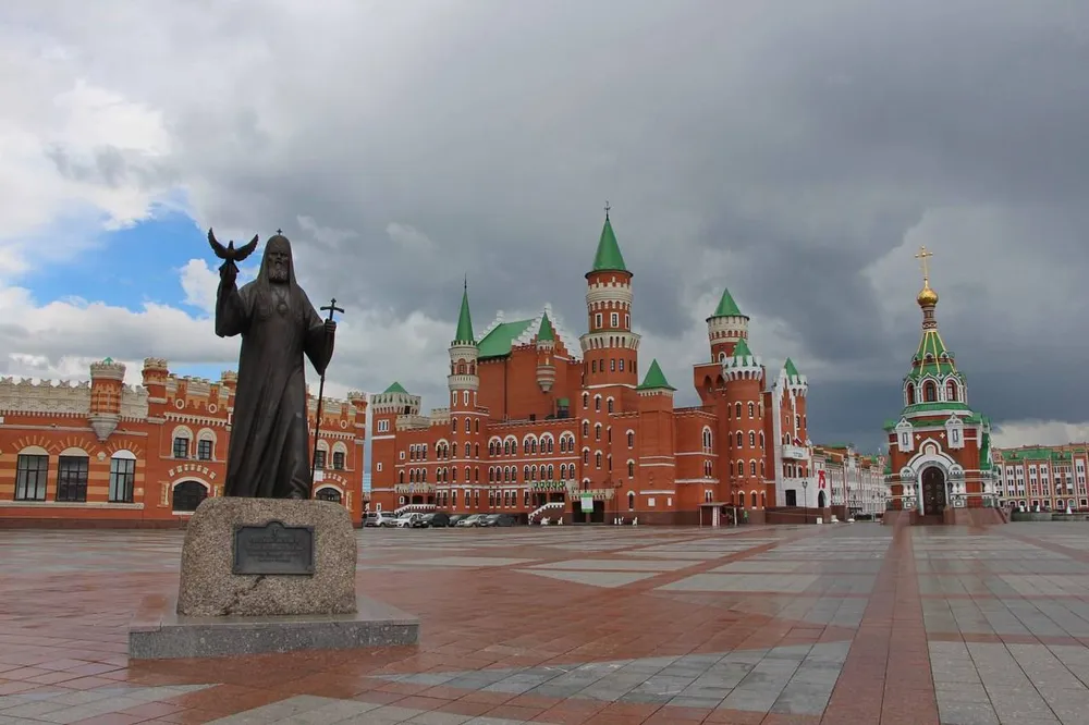 Памятник Священномученику Леониду на Патриаршей площади в Йошкар-Оле на фоне замка 12 апостолов